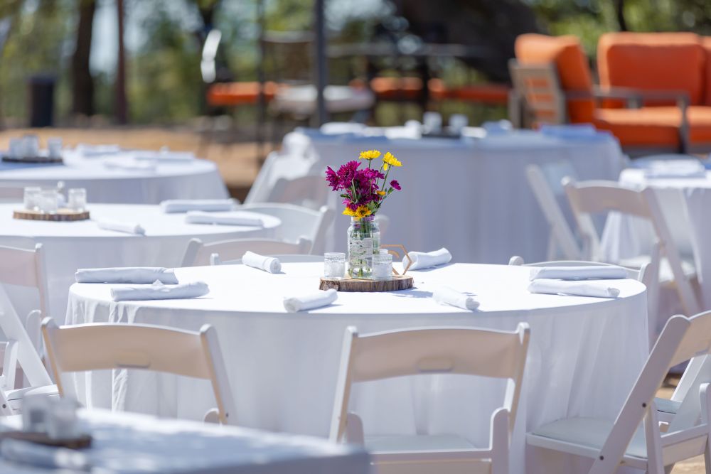 Gedeckter Tisch mit Blumenarrangement draußen