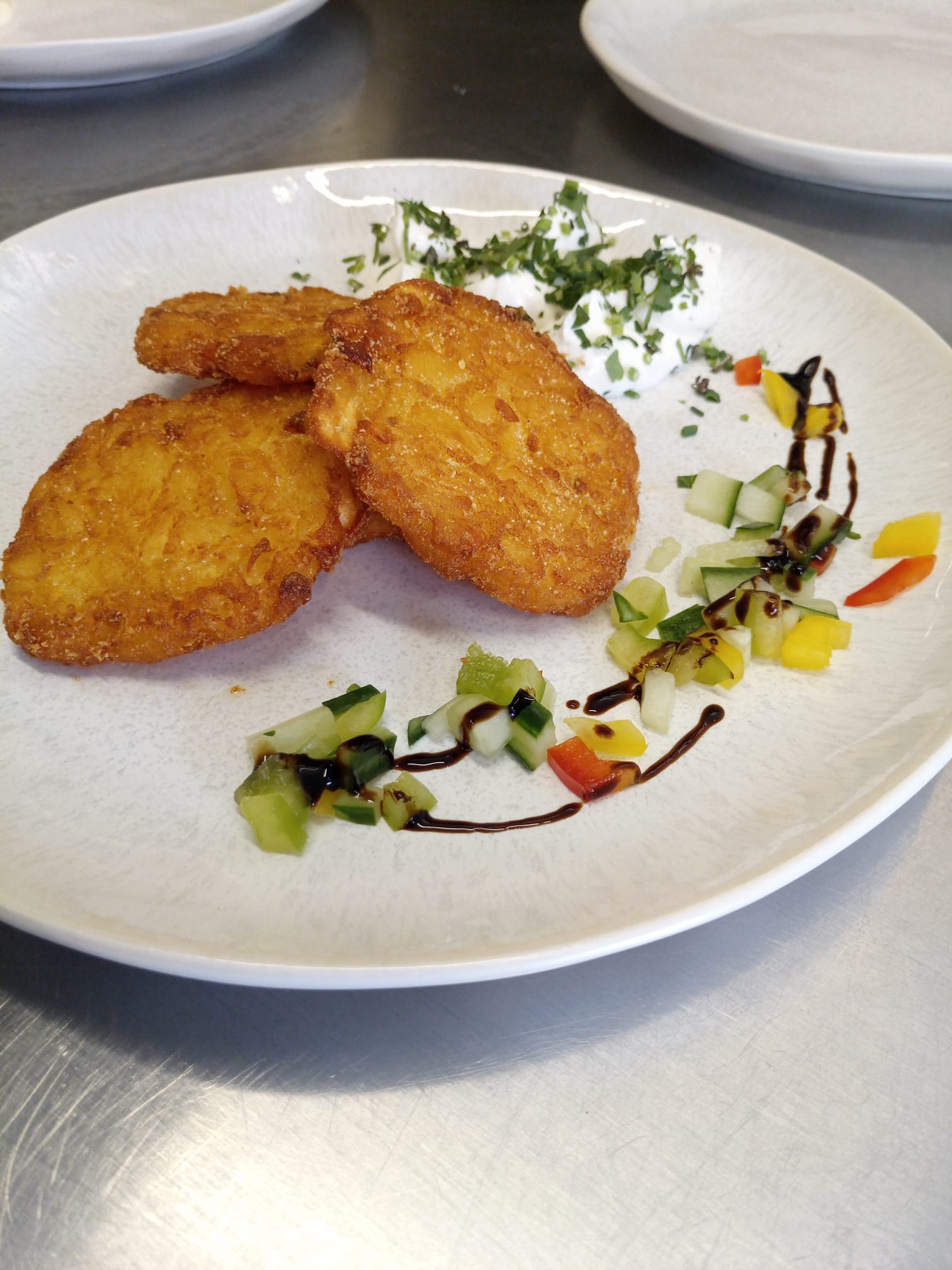 Kartoffelpuffer mit Gemüse und Dip auf Teller